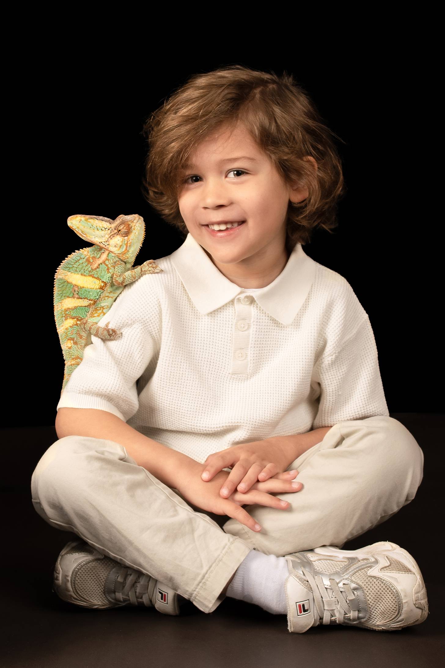 Een jongen met een kameleon op zijn bovenarm.